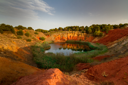This lake was a Bauxite, mine until 1976, when it was abandoned due to the infiltration of salted water coming from the sea, that has created the lake. It is located in Otranto, in the city of Puglia region, Italy. The two colors of the water are two to this mineral.の写真素材