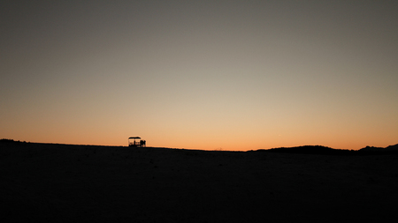 Silhouette of a group of people standing next to a cab, on a mountain landscapeの写真素材
