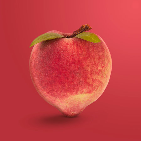 Peach With Green Leaves Isolated on Red Background.の写真素材