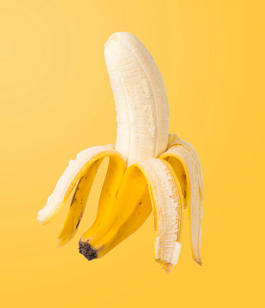 Peeled Banana on yellow background.の写真素材