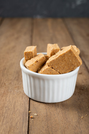 Pacoca is a Brazilian Peanut Sweet. on a white bowl on a wooden deks.の写真素材