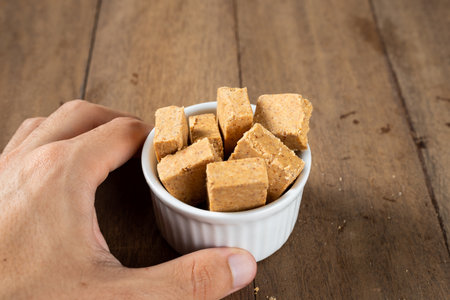 Man's Hand Holding a bowl full of Brazilian Peanut Sweet called PaÃ§oca.の写真素材