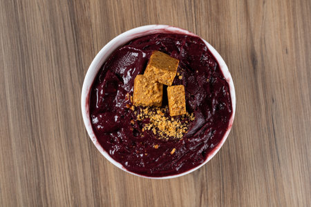 White Bowl of Brazilian Frozen AÃ§ai Berry With PaÃ§oca. on a wooden desk. Top view.の写真素材