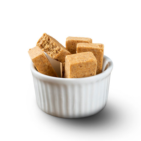 A bowl full of Brazilian Peanut Sweet called PaÃ§oca isolated on white background.の写真素材