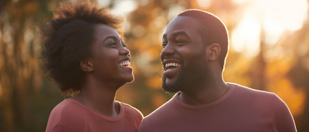 Cheerful african american couple looking at each other in autumn parkの素材