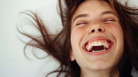 Portrait of a little girl lying on the bed and laughing.の素材