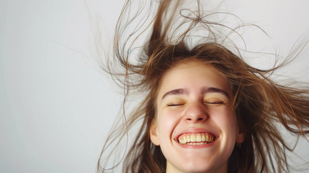 Portrait of a happy young woman with her hair in the windの素材