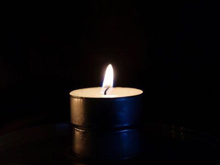 Tea candle against a black background    