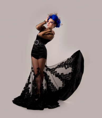 professional model in flying a black dress on grey backgroundの写真素材