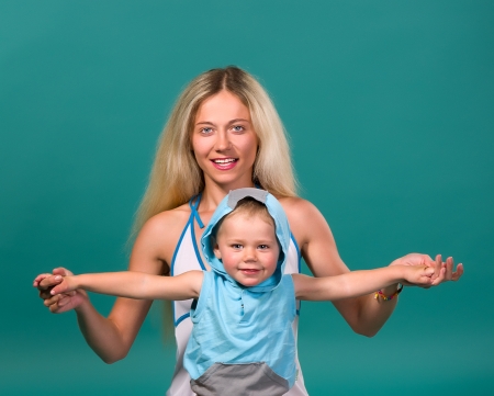 Mom keeps laughing at the hands of his son on a green backgroundの写真素材