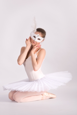 ballet dancer in a white skirt and a carnival mask  in studioの写真素材