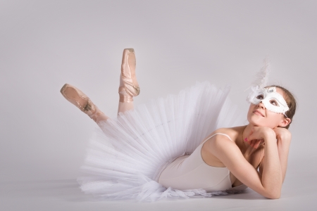 ballet dancer in a white skirt and a carnival mask  in studioの写真素材