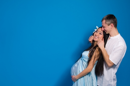 Asian pregnant woman in a silk dress on a blue background. Shooting with a mixed lightの写真素材