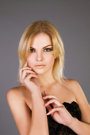 studio portrait of a beautiful blonde girl on a gray backgroundの写真素材
