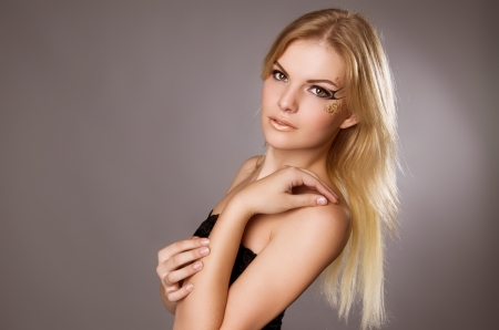 studio portrait of a beautiful blonde girl on a gray backgroundの写真素材