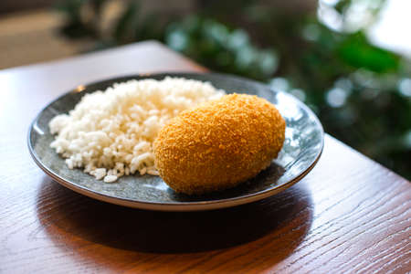 kiev cutlet with white rice on ceramic plate on wooden table backgroundの写真素材