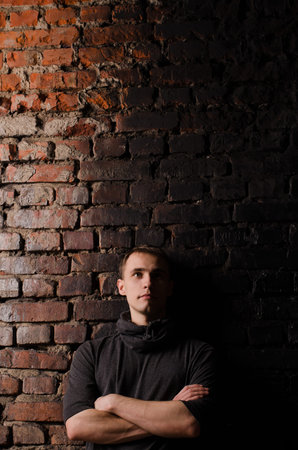 Portrait of a young man in a hat with a ribbon, close-up, on a black background, studio light