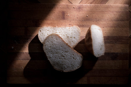 Bread on the table in front of the window.