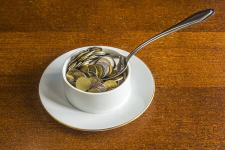 Soup plate, spoon and money.の写真素材