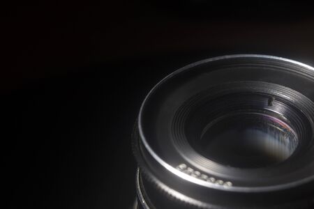 Old Soviet lens close-up on a black background in defocusの写真素材