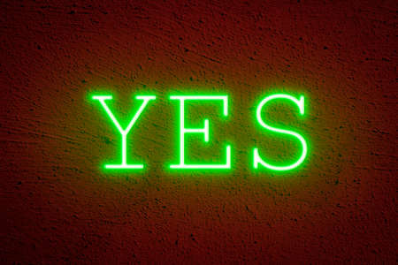 Green neon YES on a red plastered wall. Consent, approval conceptの写真素材