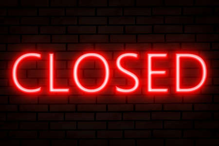 red neon lettering CLOSED on brick wall.の写真素材