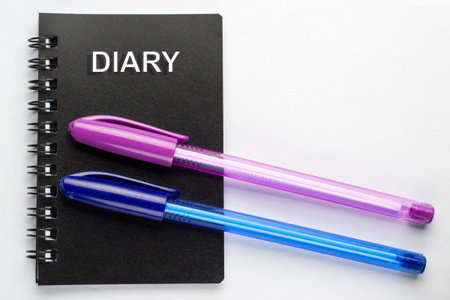 Diary and ballpoint pens on a white background. Plan for the day, business meetings.