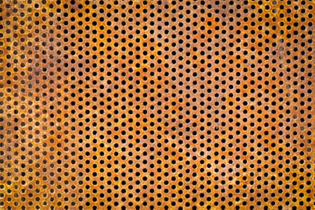 Old rusty metal canvas with holes. Retro style. Close-up. Background, wallpaper, texture, cover.の写真素材