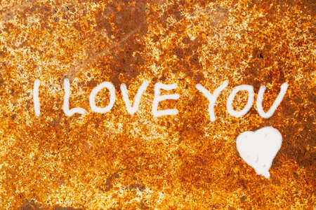 On a rusty iron surface it is written I LOVE YOU in white chalk and a heart is drawn. Declaration of love from anonymous. Romantic message.の写真素材