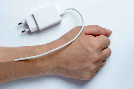 A charger implanted in the human hand. Need to recharge, exhaustion, burst of energy.の写真素材
