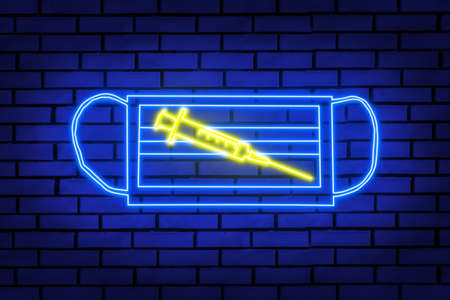 Neon sign in the form of a syringe on a medical protective mask on a brick wall.の写真素材