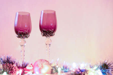 Two glasses stand on a decorated New Years table.の写真素材