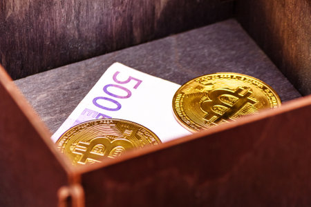 Bitcoins and euro banknote in a wooden box. Forgotten purchase. Successful investment.の写真素材