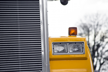 Detail of headlight and grille of yellow semi truck の写真素材