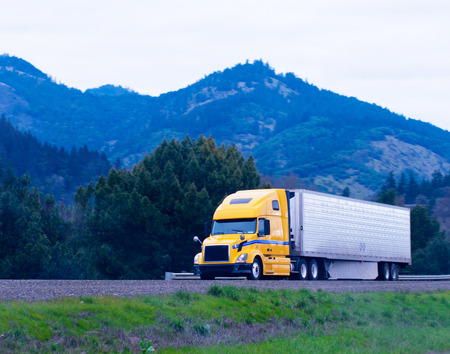 Modern popular powerful yellow big rig semi truck の写真素材