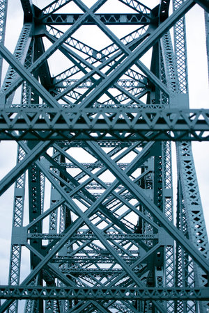 Interweaving metal truss bridge forming geometric shapes squares and triangles stretching into...