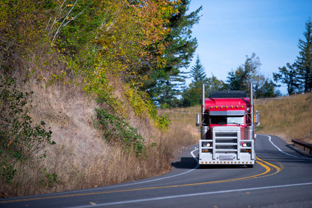 Powerful bright stylish popular professional red big rig semi truck with a protective grille from...