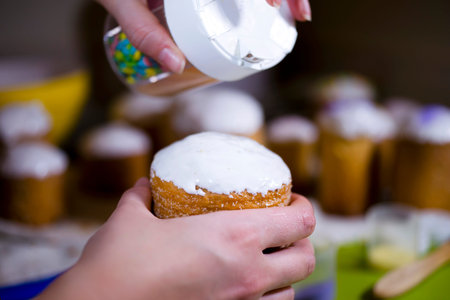 Applying colorful sweet glaze chips on top of the delicious traditional Easter baking a dough for...