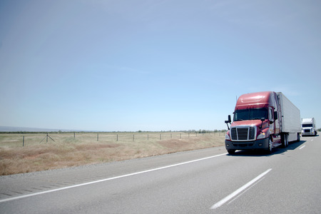 Convoy is a powerful modern semi-trucks with various types of semi trailers for transporting a wide range of manufactured goods, products and food through a network of highways connecting the whole of Americaの写真素材