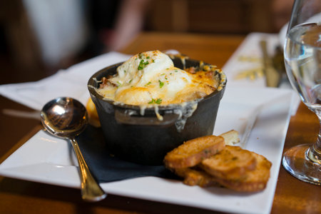 Nutritious healthy eggs poached with crispy bacon and molten Parmesan cheese on sliced potatoes,...