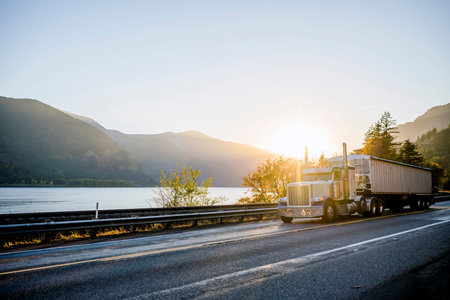 Big rig American white long haul powerful semi truck transporting commercial cargo in bulk semi...
