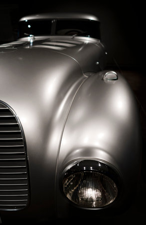 Retro Vintage silver car with chrome accents headlamp grille and bumper reminiscent of the outline...