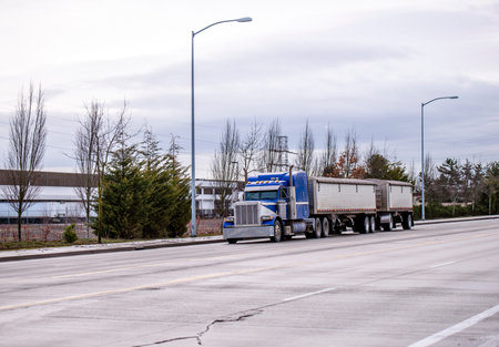 Blue classic big rig American semi truck with vertical exhaust pipes and sleeping compartment...