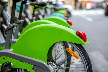 Street transportation green hybrid public rent bicycles for traveling around the Paris stand in row...