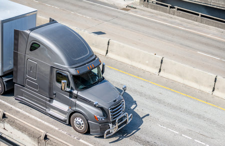 Big rig gray long haul bonnet professional heavy-duty semi truck transporting commercial cargo in...
