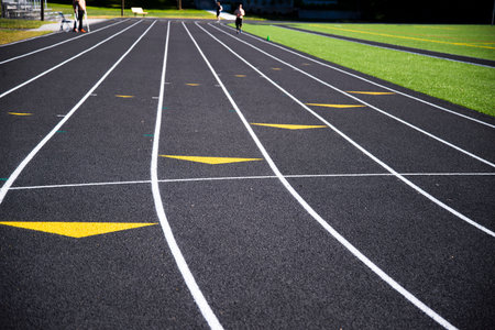 A lined multi-lane treadmill around the stadium with finish and start points and arrows invites everyone to play sports and improve their fitness with running exerciseの写真素材