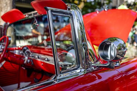 Red and white rarity executive vintage retro convertible car with open top and red leather trim and seats exhibited at traditional indoor exhibition of old cars in a small American provincial townの写真素材