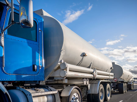 Blue big rig day cab semi truck with efficient eco-friendly diesel engine transporting fuel cargo in...