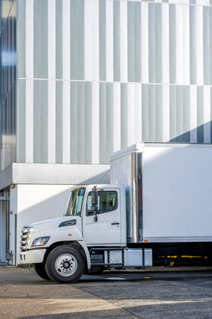 Medium duty day cab rig compact white industrial semi truck with box trailer for local deliveries...
