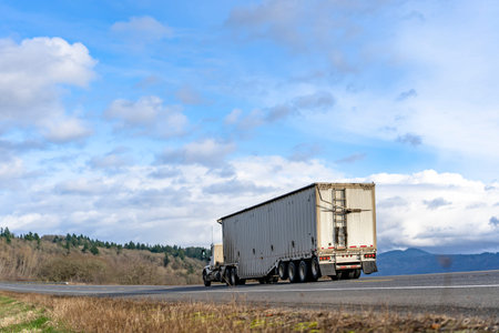 Industrial transportation Big rig classic semi truck with powerful diesel engine transporting heavy...